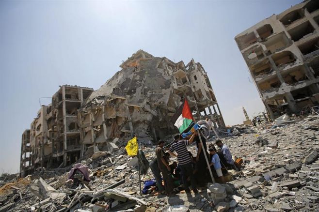 Un grupo de palestinos se re�ne entre los escombros de las torres Al-Nada en la ciudad de Beit Lahia (Franja de Gaza) hoy, lunes 11 de agosto de 2014. Las primeras horas del alto el fuego que entr� en vigor la pasada medianoche entre Israel y las milic. EFE Un grupo de palestinos se re�ne entre los escombros de las torres Al-Nada en la ciudad de Beit Lahia (Franja de Gaza) hoy, lunes 11 de agosto de 2014. Las primeras horas del alto el fuego que entr� en vigor la pasada medianoche entre Israel y las milic. EFE