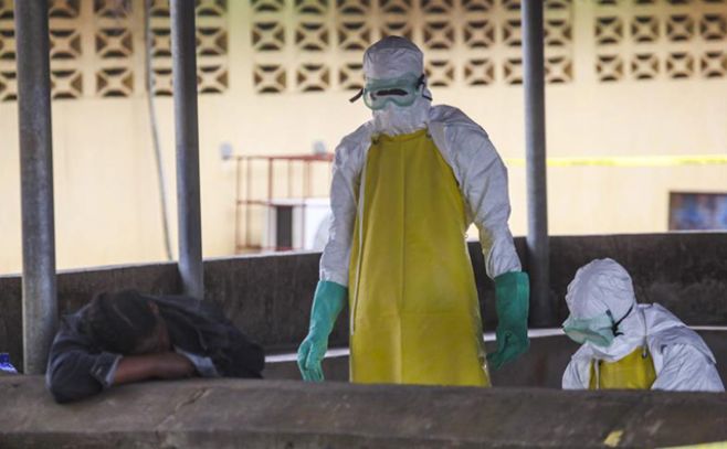 Archivo. Trabajadores de salud liberianos se preparan para recoger el cuerpo de una vctima del bola del rea de espera de un hospital en Monrovia (Liberia).. EFE