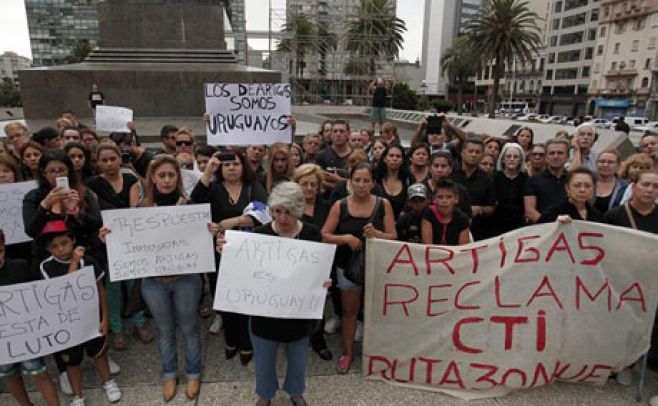 Personas agrupadas en Plaza Independencia portando pancartas en memoria de los fallecidos.. EFE