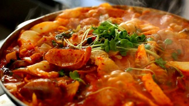 El budae jjigae, un tipo de sopa coreana espesa, fue inventado durante la Guerra de Corea (1950-1953), cuando la comida escaseaba. La gente utilizaba las sobras de las bases militares estadounidenses, como perros calientes o carne enlatada, y la aadan