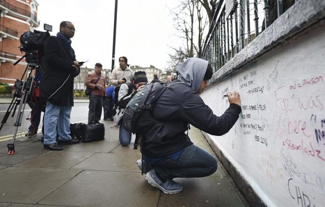 Un hombre escribe un mensaje de agradecimiento al exproductor de los Beatles George Martin en un muro junto a los estudios Abbey Road en Londres. EFE