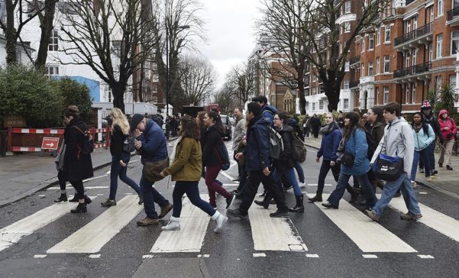 Seguidores de los Beatles cruzan el famoso paso de cebra junto a los estudios Abbey Road en Londres en homenaje a Martin.. EFE