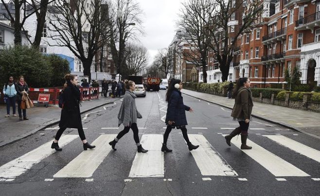 Seguidores de los Beatles cruzan el famoso paso de cebra junto a los estudios Abbey Road en Londres en homenaje a Martin.. EFE